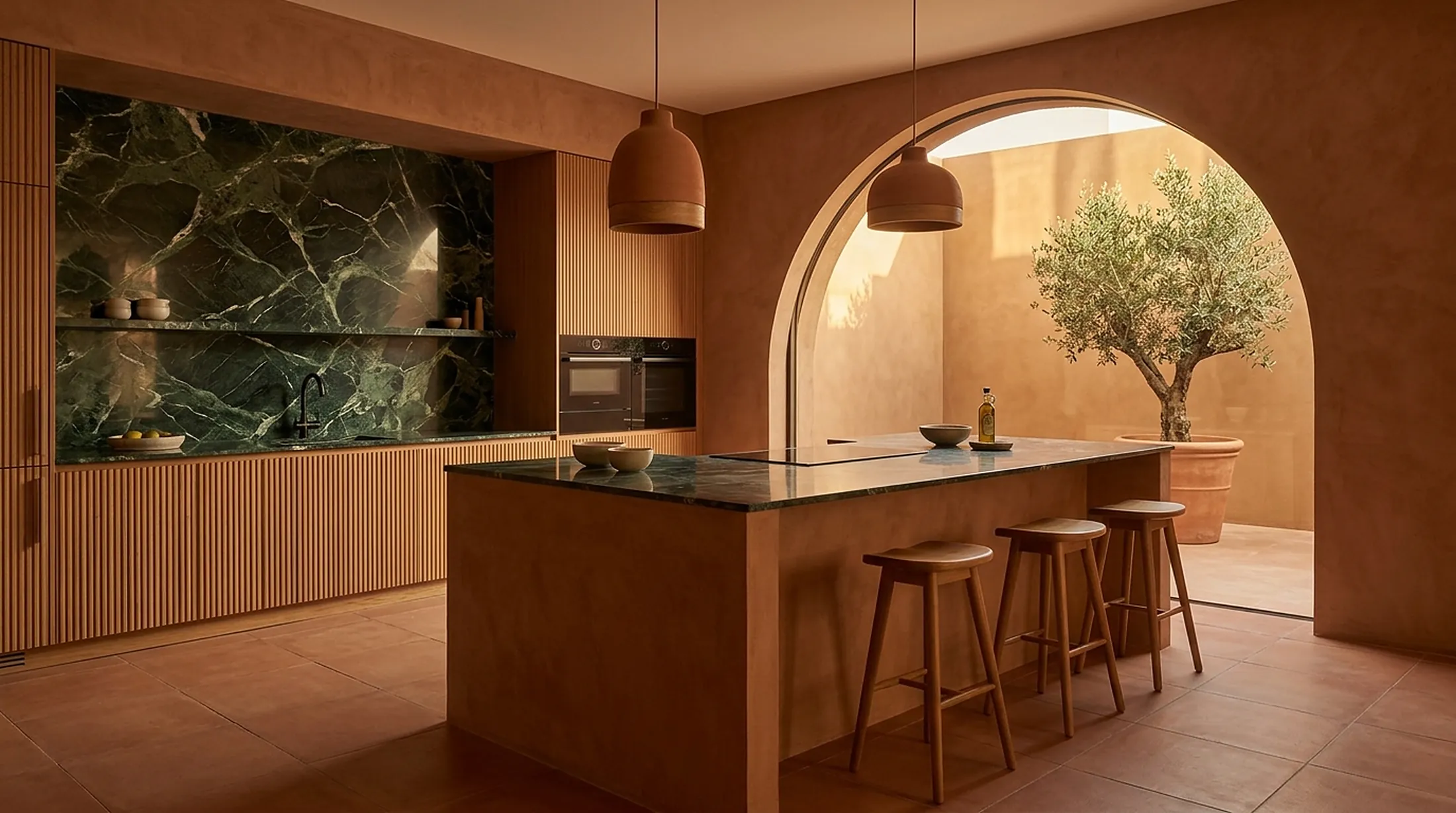 Terracotta kitchen with green marble island and courtyard arch