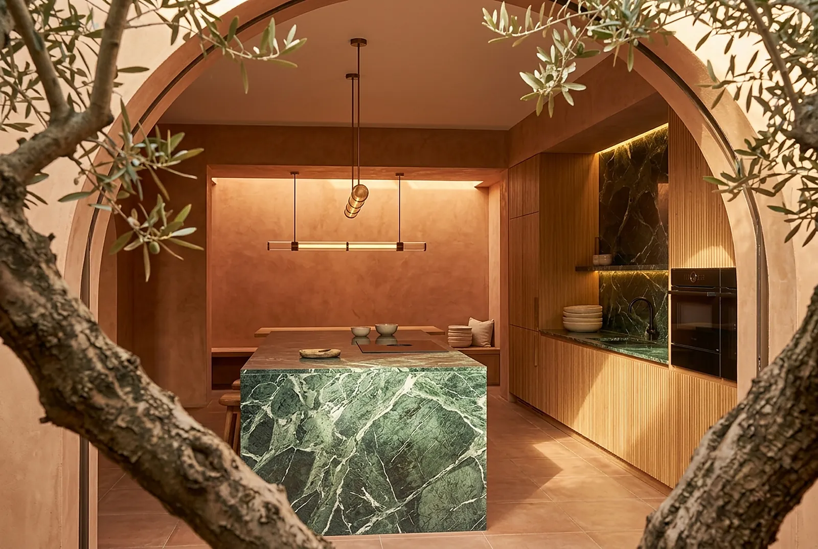 Kitchen seen through the courtyard arch and olive branches