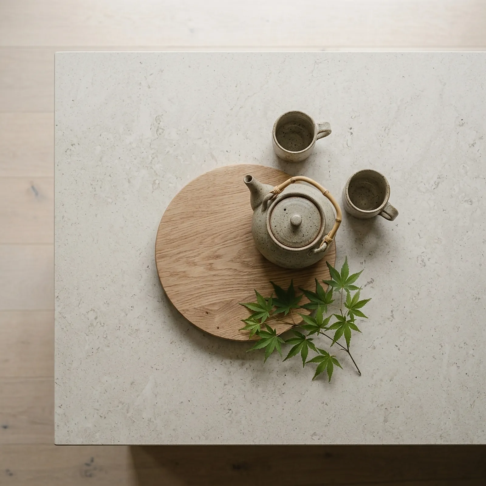 Teapot and cups on a pale limestone worktop